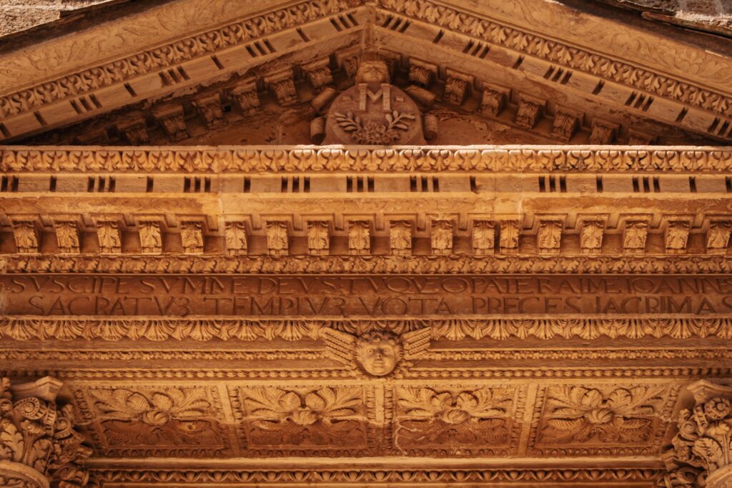 Dettaglio del frontone scolpito della chiesa di San Giovanni Elemosiniere